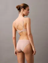 Conjunto de ropa interior color piel, compuesto por un sujetador sin aro y una bombacha tipo bikini. El sujetador tiene tirantes finos y ajustables, y la bombacha es de corte clásico.
