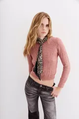 Sweater rosa de tejido calado con lentejuelas, corte ajustado y mangas largas.