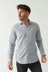 Camisa de hombre a rayas verticales celestes y blancas, corte slim fit, manga larga, logo bordado en el pecho y cartera con botones.