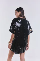 Remerón vestido negro con lentejuelas y estampado de estrellas doradas.