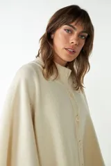 Capa marrón de tejido de punto 100% lana fina sin teñir, con botones y bolsillos en la delantera. Diseño exclusivo de Don Baez, hecha en Uruguay.