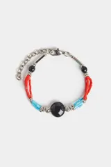 Pulsera elástica con tres hilos de cuentas de vidrio rojas y celestes, separadas por cuentas plateadas con diseño calado.