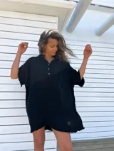 Túnica de playa negra con cuello mao, mangas cortas y ruedo con flecos.