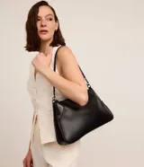 Bolso de hombro negro con textura croco, confeccionado en poliuretano. Cuenta con cierre de hebilla, asa de mano y correa larga desmontable.