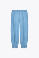 Pantalón jogger celeste confeccionado en lino, con tiro alto, cintura elástica ajustable con cordón, bolsillos delanteros y puños elásticos en el bajo.