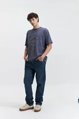 Remera marrón de manga corta con cuello redondo y estampado con texto en el frente.