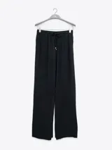 Pantalón palazzo negro de crepe con cintura elastizada, bolsillos laterales y terminaciones con logo en cobre.
