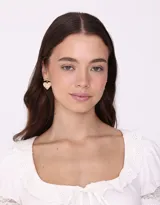 Aros colgantes dorados con forma de corazón y moño en la parte superior.