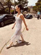 Vestido corto tejido en lurex con diseño geométrico en cuero en el frente, breteles de cuero intervenido a mano con tientos de cuero plateado y terminación en flecos.