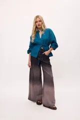 Chaqueta azul con cuello mao, mangas largas abullonadas y lazo en la cintura.