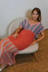 Vestido tejido con hilo de algodón en punto calado con un diseño de rayas verticales. Escote V, manga corta y falda amplia con tajos laterales que aportan movimiento.