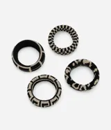 Kit de cuatro gomitas para el pelo de tejido de punto, en colores negro y beige. Incluye dos diseños: uno con patrón geométrico tipo greca y otro con patrón animal print abstracto.