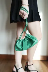 Cartera sobre azul de cuero con frunces y pespuntes diagonales.