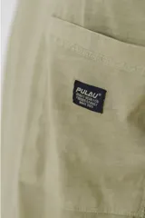 Remera color beige de corte holgado, con cuello redondo y bolsillo en el pecho.