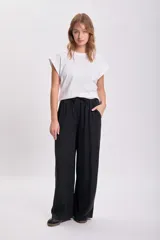 Pantalón negro de vestir de corte palazzo con cintura alta y lazo ajustable.
