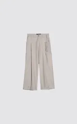 Pantalón cargo de tiro alto, color beige claro, con corte ancho y largo. Presenta pliegues frontales y bolsillos cargo amplios a los costados de las piernas. Los bajos tienen un broche metálico para ajuste.