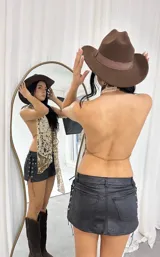 Top con estampado de vaca, corte halter y lazos ajustables en el frente.