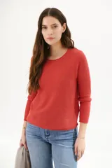Sweater de punto color ladrillo, de corte clásico y mangas largas.