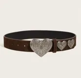 Cinto marrón de gamuza con hebilla plateada en forma de corazón y apliques de corazones plateados.