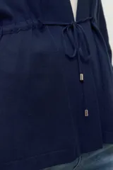 Ruana de tejido de punto color marrón chocolate, con cuello redondo y mangas largas.