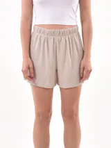 Short de tela color beige con cintura elástica.