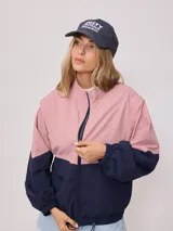 Campera rompevientos Rusty de nylon, color rosa y azul marino, con cierre frontal y puños elastizados.