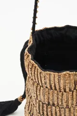 Cartera de noche tipo bolso redondo, confeccionada con lentejuelas y canutillos dorados. Cuenta con cordón de ajuste con borlas negras y correa al tono con apliques de canutillos.