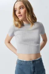 Top gris de tejido de punto acanalado, elastizado, de manga corta y cuello alto.