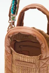 Cartera tote mini color negro, confeccionada en tejido tipo rafia. Cuenta con bolsillos internos, dos correas desmontables y abertura superior con cierre.
