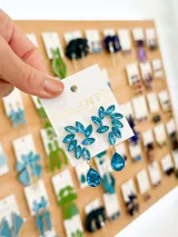 Aros colgantes con forma de abanico, con engarce de gemas facetadas color celeste y base dorada.