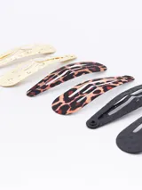 Pack de seis hebillas para el pelo tipo sapitos, con diseños variados: dos plateadas con textura, dos negras lisas y dos con estampado animal print en blanco y negro.