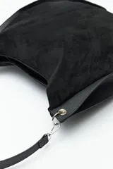 Bolso tipo hobo de cuero sintético negro con panel frontal de gamuza. Tiene correa de hombro ajustable y logo metálico plateado.