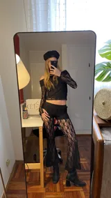 Conjunto de top y pantalón de encaje negro. El top es de escote bardot y mangas largas acampanadas. El pantalón es de corte palazzo.