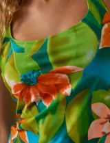 Tankini de dos piezas, musculosa con estampado de círculos negros y verdes sobre fondo blanco, con escote cuadrado, copa armada y sujetador interno. Incluye bombacha negra lisa.