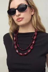 Top negro de cuello recto, sin mangas y terminación en pico.