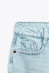 Pantalón de jean celeste claro, de corte mom fit, tiro alto y largo tobillero.