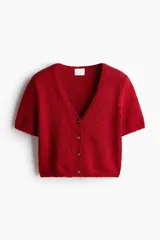 Cárdigan rojo de tejido slub con cuello en V, manga corta y cierre frontal con botones.