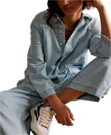 Mono largo de denim celeste, con cuello camisero, cierre frontal con botones y bolsillos cuadrados.