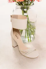 Sandalia de cuero vacuno color negro, con tiras finas en la parte delantera y pulsera ancha en el tobillo con cierre trasero. Taco ancho de 9 cm.