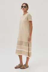 Vestido midi de tejido de punto color beige, con escote redondo, mangas cortas, tajos laterales y diseño con patrón de puntos calados y rayas.