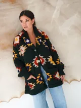 Saco de lana marrón con diseño geométrico multicolor, cuello con solapa, cierre frontal con botones y bolsillos delanteros.
