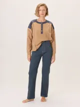 Buzo de manga larga con diseño de bloques de color y textura. El cuerpo principal es marrón, la espalda superior y hombros tienen un panel de tejido a rayas grises y azules, y los hombros superiores son de color beige rosado. Presenta costuras decorativas en rojo que separan los bloques de color.