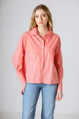 Camisa de algodón a rayas verticales color salmón y blanco, con cuello clásico, cierre frontal con botones y mangas largas.