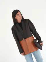 Blazer marrón de lana con solapas anchas, mangas abullonadas y puños ajustados. Parte inferior de cuero color caramelo.