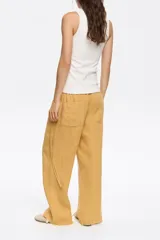 Pantalón mostaza de corte amplio y tiro alto, con cintura elástica.