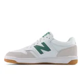 Championes New Balance BB480 de cuero blanco con detalles en verde y suela de goma color caramelo.