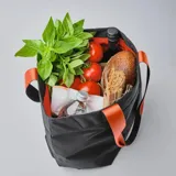 Bolso tote negro con asas de correa negras con interior naranja, cierre principal, bolsillos de acceso rápido y seis bolsillos internos.
