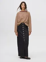 Falda midi de denim color marrón con hilado a la vista en el ruedo y abotonadura frontal.