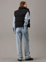 Chaleco puffer negro Calvin Klein Jeans con logo bordado en el pecho, cuello alto, cierre frontal con botones a presión y bolsillos laterales.