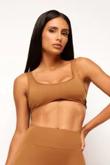 Top deportivo gris con escote cuadrado, breteles anchos y calce ajustado. Incluye forro interno y apertura para almohadilla removible.